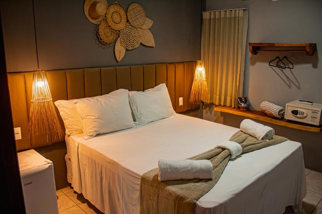 Un dormitorio con una gran cama blanca con dos lámparas. en Pousada Villa Uçá Frances - Praia do Frances, en Praia do Frances