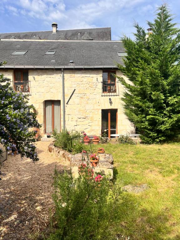an old stone house with a garden in front of it at Abbaye Cottage - Maison entière - jardin - jacuzzi in Fontevraud-l'Abbaye