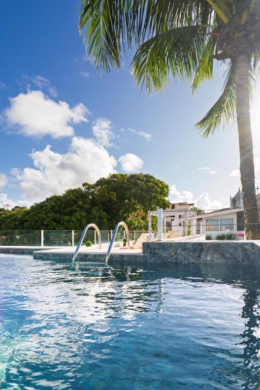 a swimming pool with a palm tree in the background at Morro de São Paulo - Boho Loft Escape Pool Balcony & Champagne in Cairu