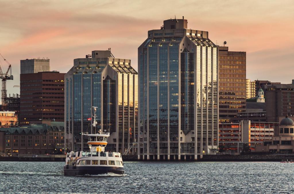 a boat in the water in front of a city at Staybridge Suites Halifax - Dartmouth by IHG in Halifax