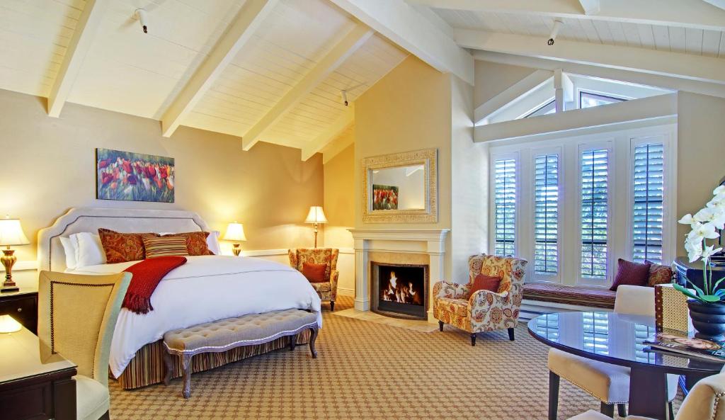 a hotel room with a large bed and a fireplace at Carriage House Inn in Carmel