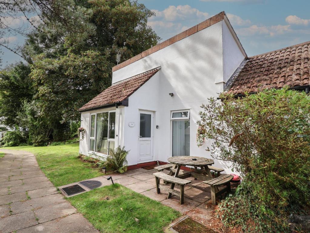 a white house with a picnic table and a picnic table at Manorcombe 1 in Gunnislake