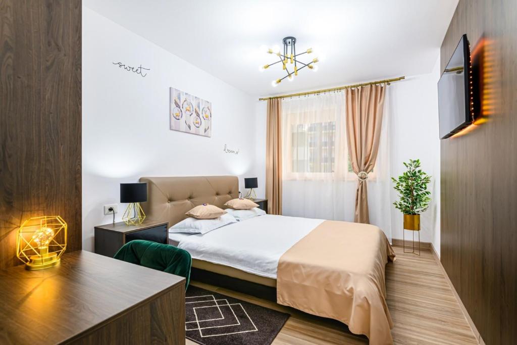a bedroom with a bed and a desk and a window at OCCO by the Mountains in Braşov