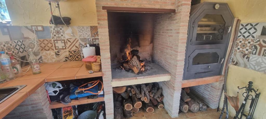 a brick oven with a fire in it in a kitchen at Casa Rural Alma de Campo in Collado de Gil