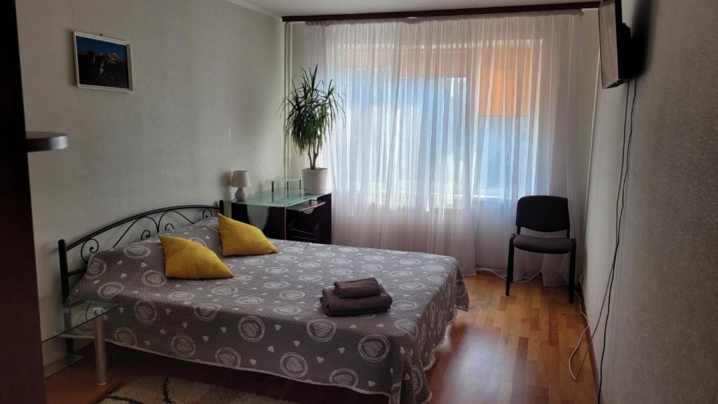 a bedroom with a bed and a desk and a window at Затишна квартира в центрі Оболоні м Київ in Kyiv