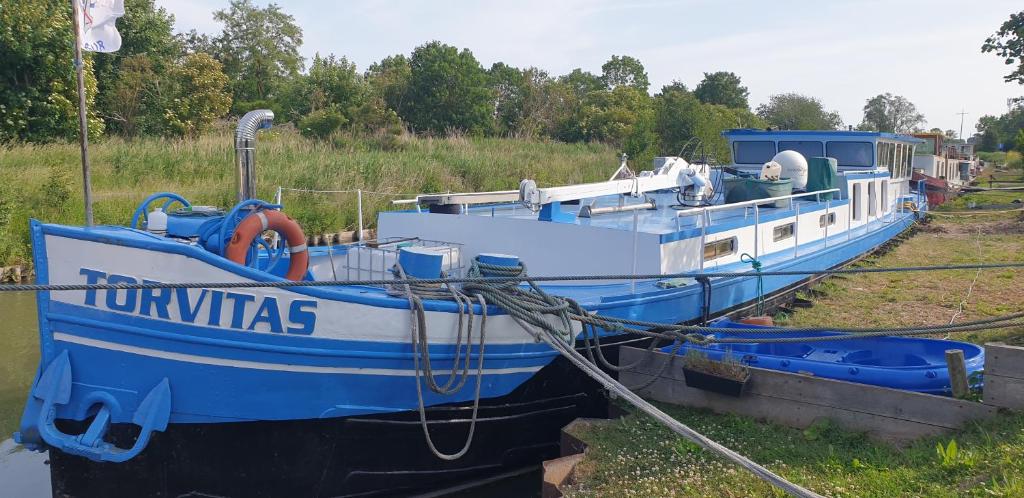 a blue and white boat sitting in the water at Séjour confortable sur péniche luxueuse in Brouckerque