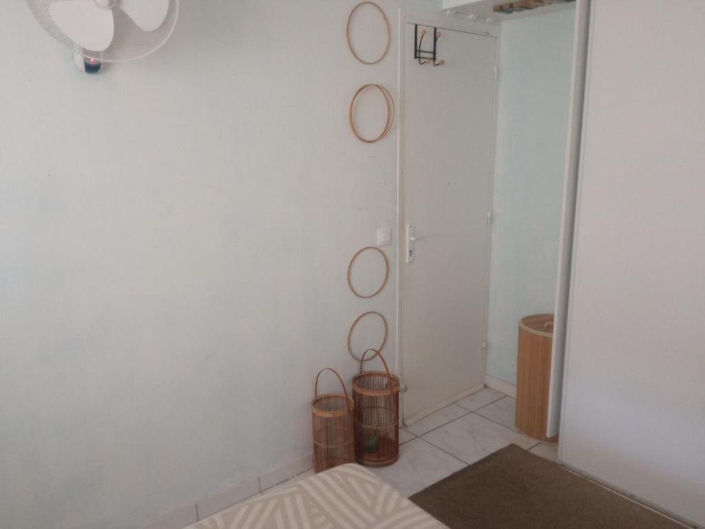 a room with a white wall with three round mirrors at Chambre d'hôte in Fort-de-France