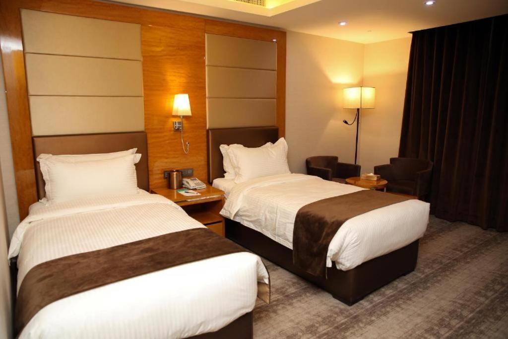 a hotel room with two beds and a desk at Petra Breeze in Wadi Musa