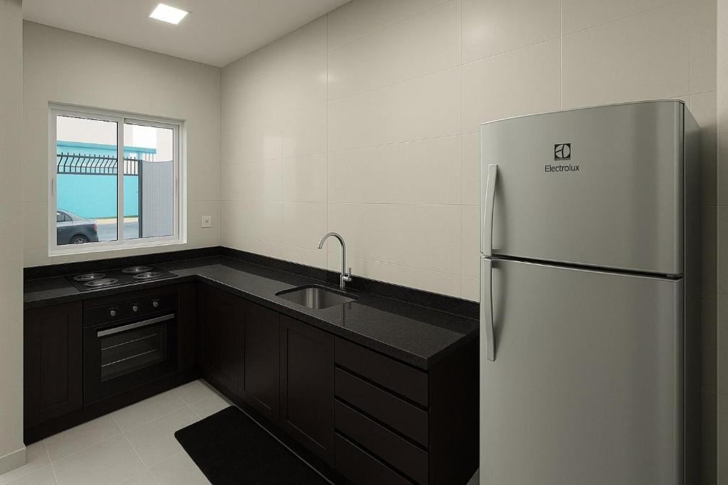 La cuisine est équipée d'un réfrigérateur et d'un évier. dans l'établissement Casa em foz do iguaçu, à Foz do Iguaçu