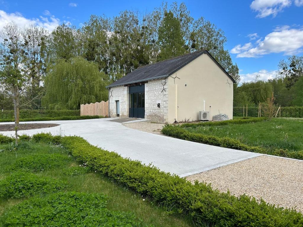 a white building with a black roof at La Ruche Enchantée in Champigny-sur-Veude