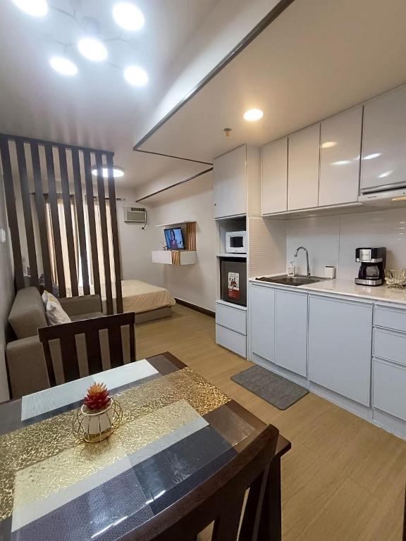 a kitchen and living room with a table and a couch at Cozyluxe at Pine Suites Tagaytay in Kaybagal