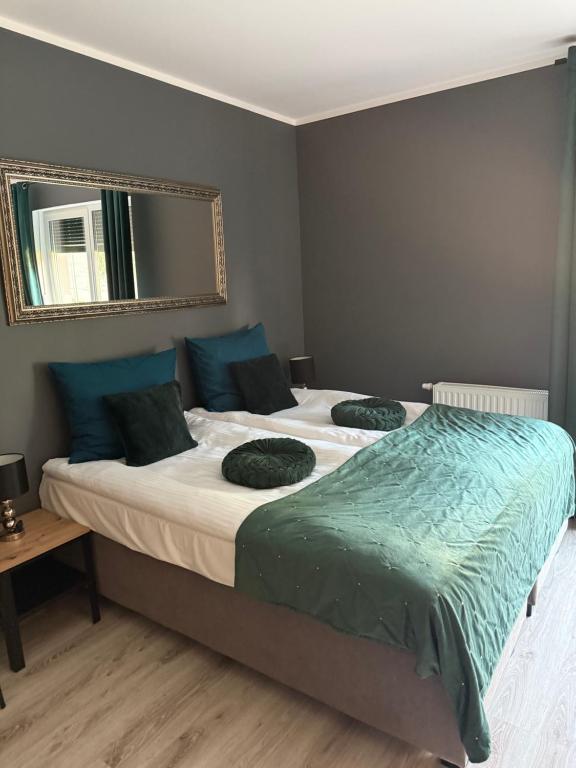 a bedroom with two beds with blue pillows and a mirror at Apartament Roma in Pniewy