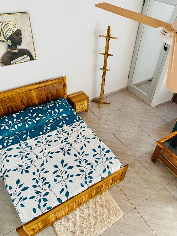 ein Bett in einem Zimmer mit einem Kreuz an der Wand in der Unterkunft Résidences Lysette 3 in Bouaké