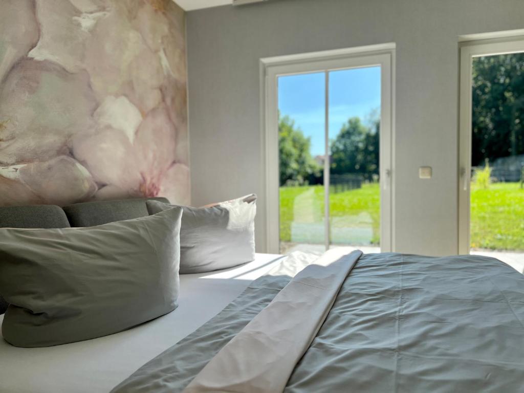 a bedroom with a large bed and a large window at Ferienwohnung Bertchen - barrierefrei mit Südterrasse und Carport in ruhiger Altstadtlage von Ballenstedt in Ballenstedt