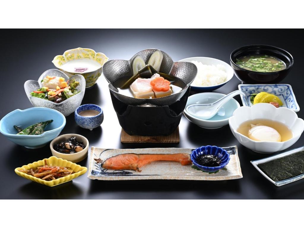 草津町にあるOsakaya Ryokan - Vacation STAY 37098vの様々なボウルや皿に食べ物が盛られたテーブル