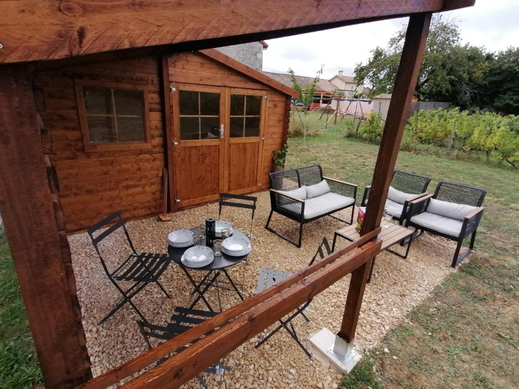 een patio met een tafel en stoelen voor een hut bij Cabane Feuille - Glamping on a vineyard - Wooden Cabin in Savigné