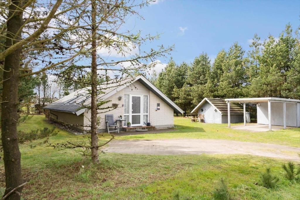 a small white house in the middle of a yard at 30051-Ulfborg-Snerlevej-483 in Vang