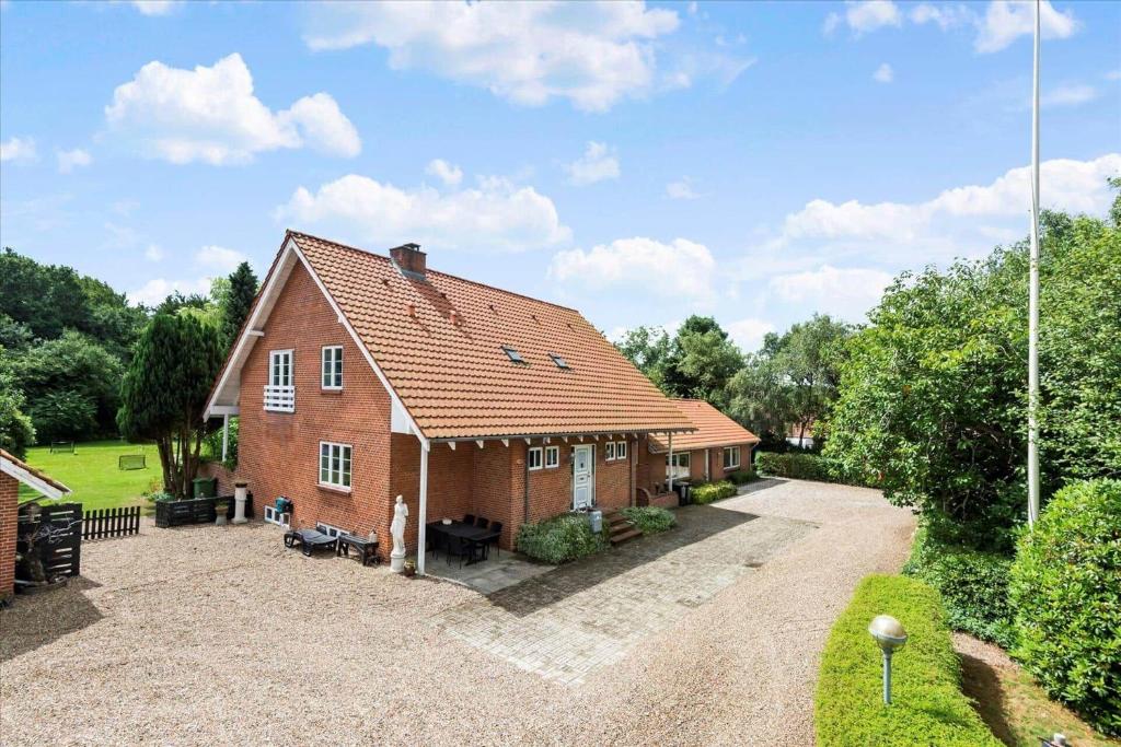 a red brick house with a gravel driveway at C11605-Olgod-Herningvej-10 in Ølgod