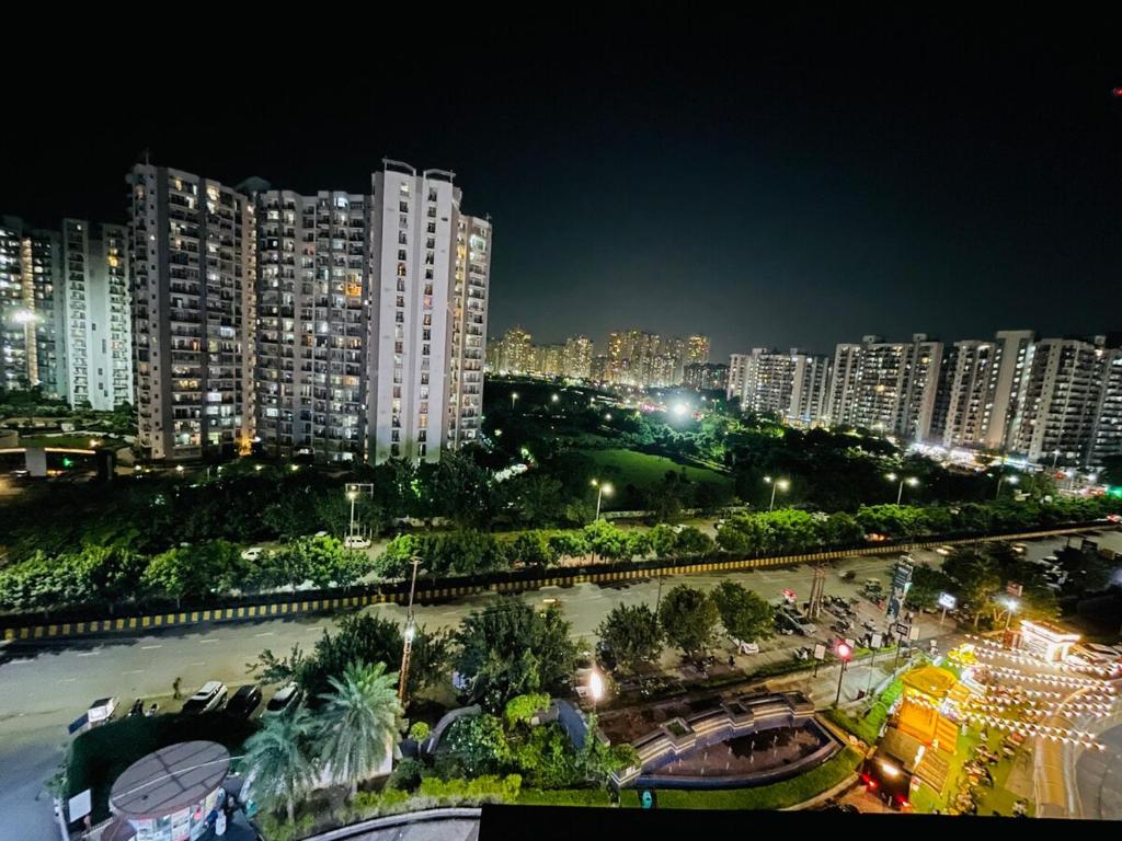 a view of a city at night with tall buildings at Premium 2BHK Stay Spacious Stylish in Noida in Noida