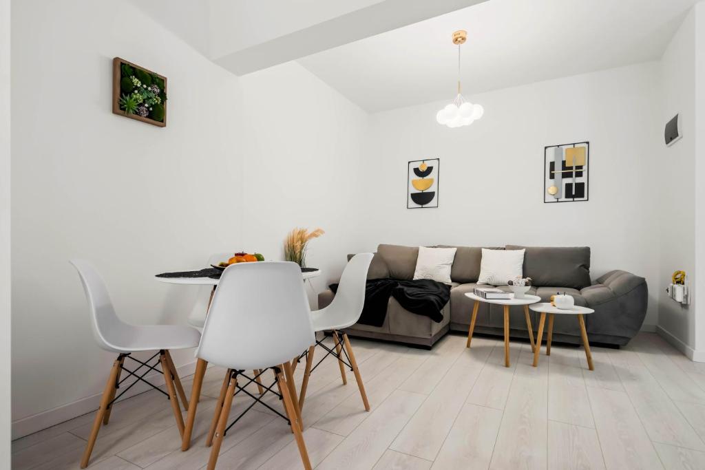 a living room with a couch and a table and chairs at NeoLoft 1st in Popeşti-Leordeni