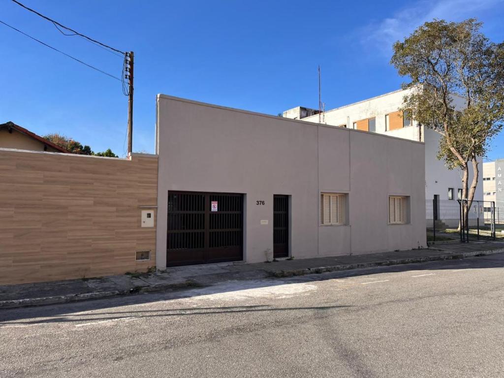 een groot wit gebouw met een deur op een straat bij Keller Reservas in Resende