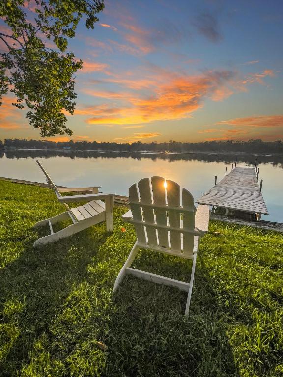 a bench sitting on the grass next to a dock at Fishing Kayaks Firepit Paddleboat in Pierceton