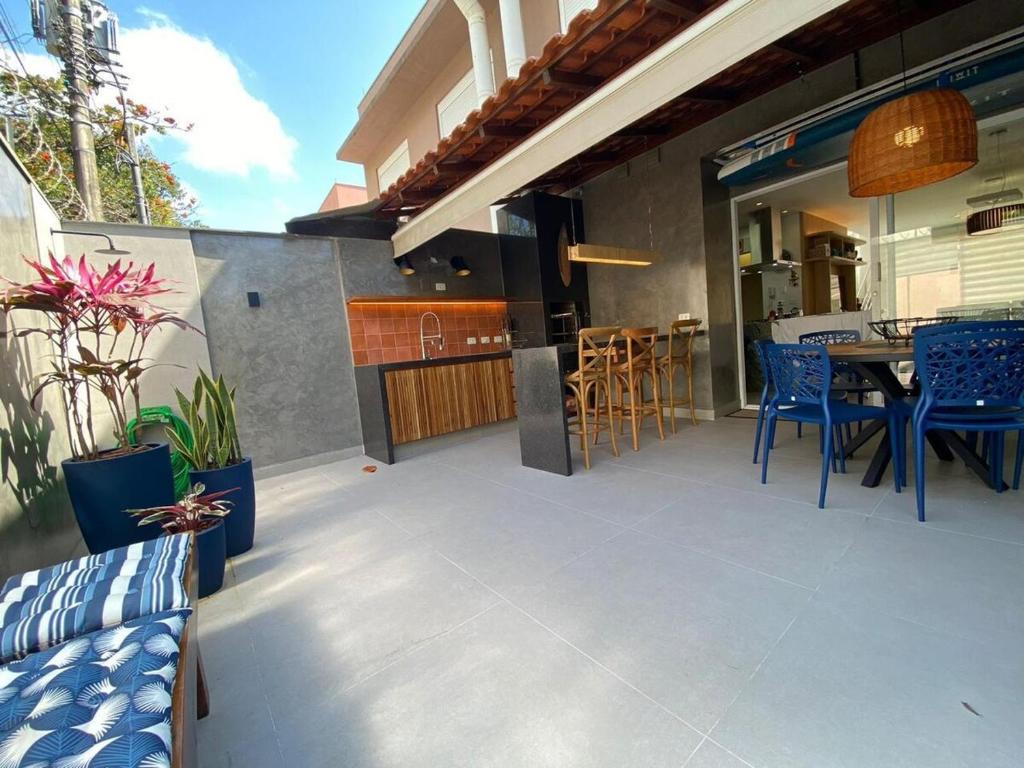 a patio with chairs and a table and a kitchen at Casa de Praia Pé na Areia Boiçucanga 6 in São Sebastião