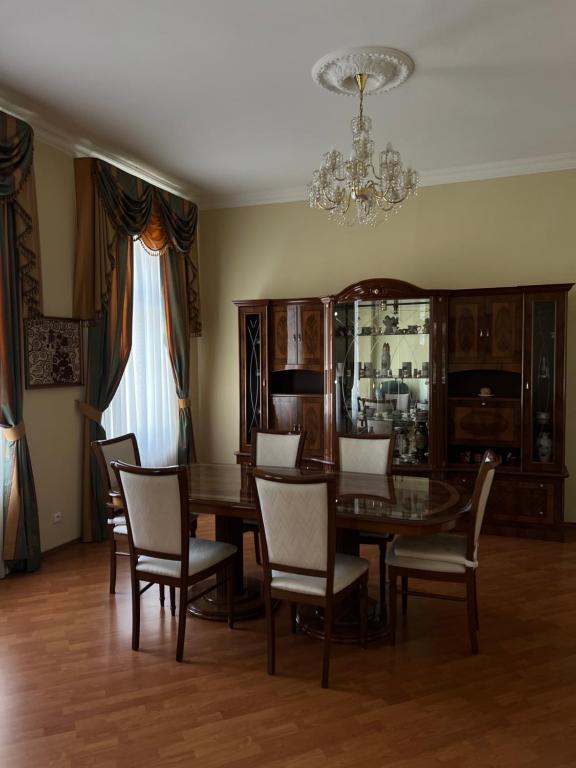 ein Esszimmer mit Tisch und Stühlen und einem Kronleuchter in der Unterkunft Apartment Zahradní 31 in Karlsbad