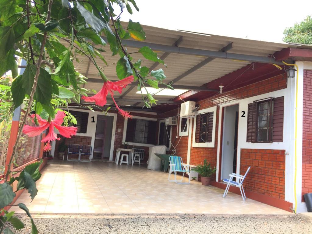 a porch of a house with chairs and awning at Casa Férias Foz in Foz do Iguaçu
