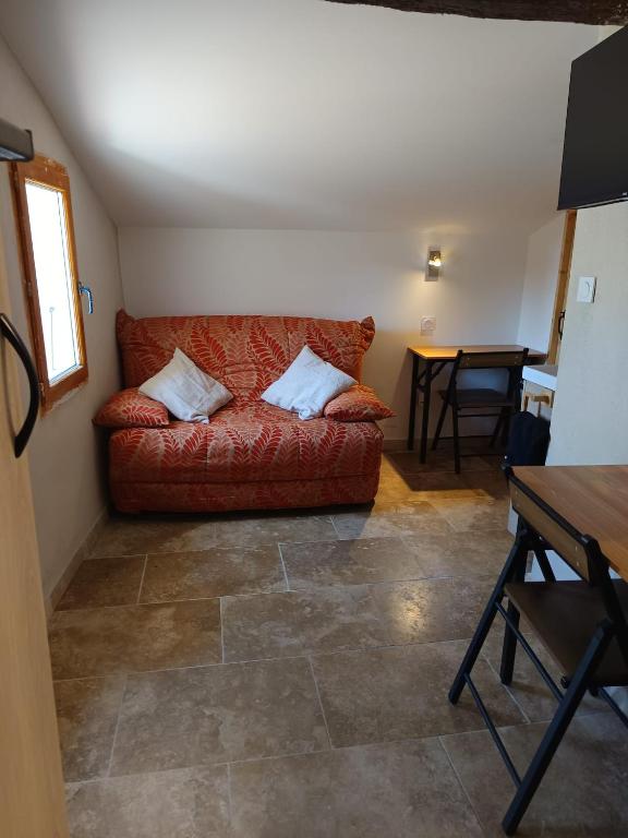 a living room with a red couch and a table at Le Nid Douillet in Arles
