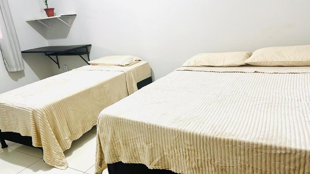 zwei Betten nebeneinander in einem Zimmer in der Unterkunft Lar Aconchego in Palmas