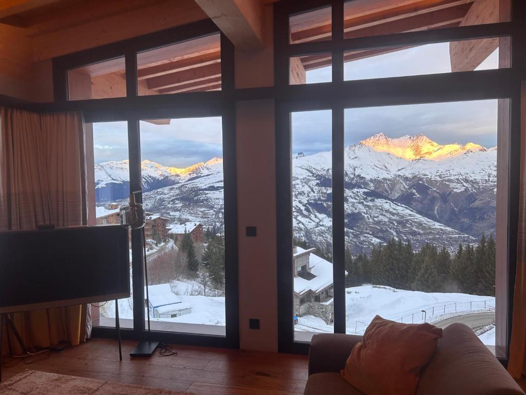 a living room with a view of a snowy mountain at Appartement de luxe les Arcs 4 chambres skis aux pieds in Arc 1800