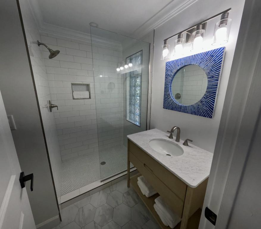 a white bathroom with a sink and a shower at Townhouse Villa 2 The Village at Hoopers Bay in New Providence Island