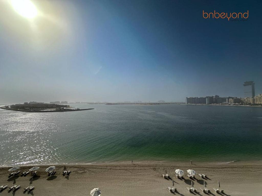 a beach with a group of umbrellas on the beach at Exclusive Home with Private Beach in Dubai