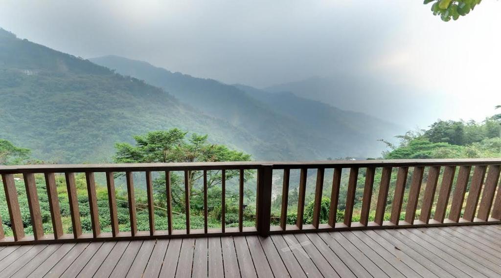 a wooden deck with a view of a mountain at Alishan Fenqihu Green Land Homestay in Guanghua