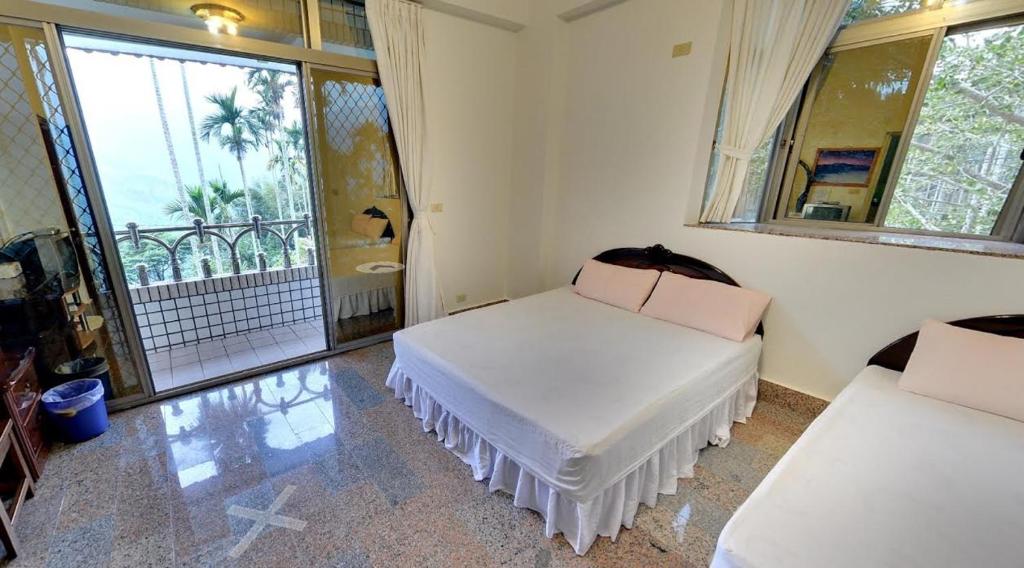 a bedroom with two beds and a balcony at Alishan Fenqihu Green Land Homestay in Guanghua