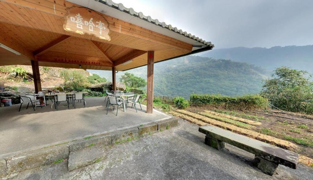 un pabellón con mesa, sillas y banco en Alishan Fenqihu Green Land Homestay, en Guanghua