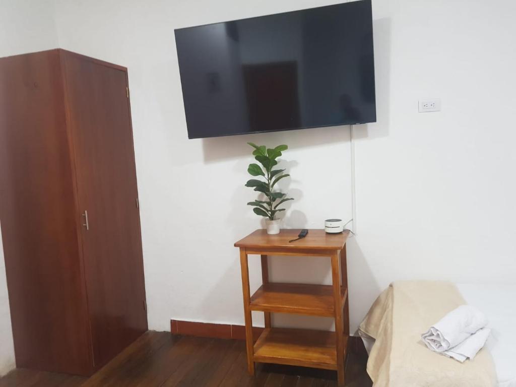 a flat screen tv hanging on a wall with a table at HOTEL EL SOL dEL GALERAS in Pasto