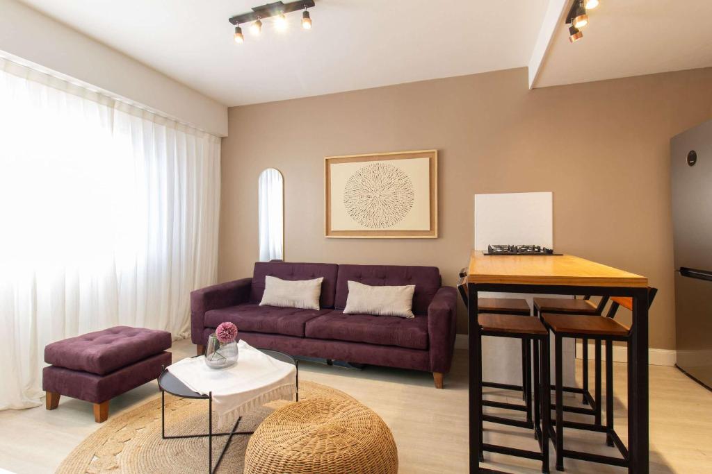 ein Wohnzimmer mit einem lila Sofa und einem Tisch in der Unterkunft Modern stay near River Plate's Stadium by deppto in Buenos Aires