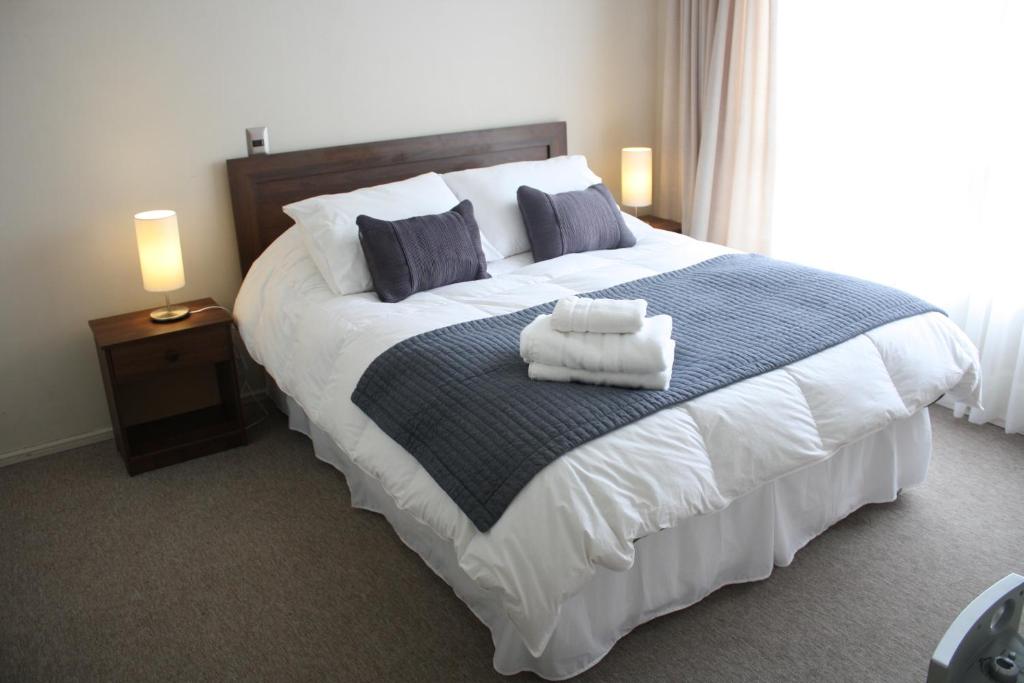 1 dormitorio con 1 cama grande y toallas. en Hostal Buró, en Concepción