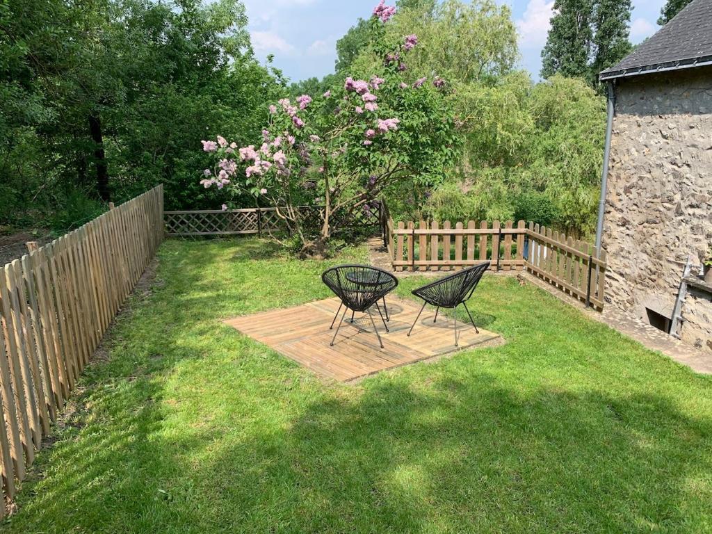 two chairs and a table in a yard at Appartement dans maison avec jardin privatif 