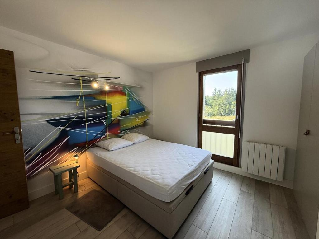 a bedroom with a bed with a painting on the wall at Résidence Herbouilly - APPARTEMENT T2 STANDING PIED DES PISTES MAE-5783 in Corrençon-en-Vercors