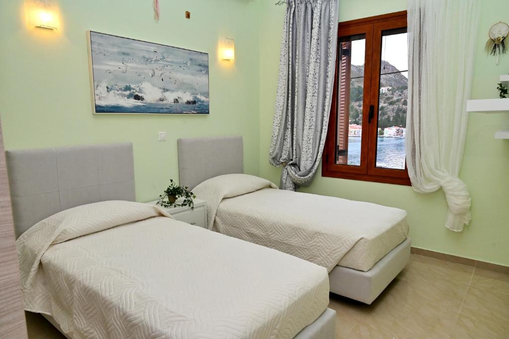 twee bedden in een kamer met een raam bij Voula's Traditional House in Meyisti