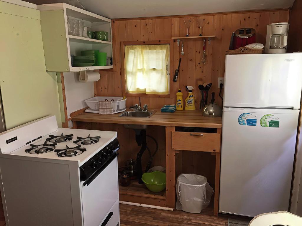 y cocina con fogones blancos y nevera. en 1-Bedroom Cottage #2 - Ambleside, en Kawartha Lakes