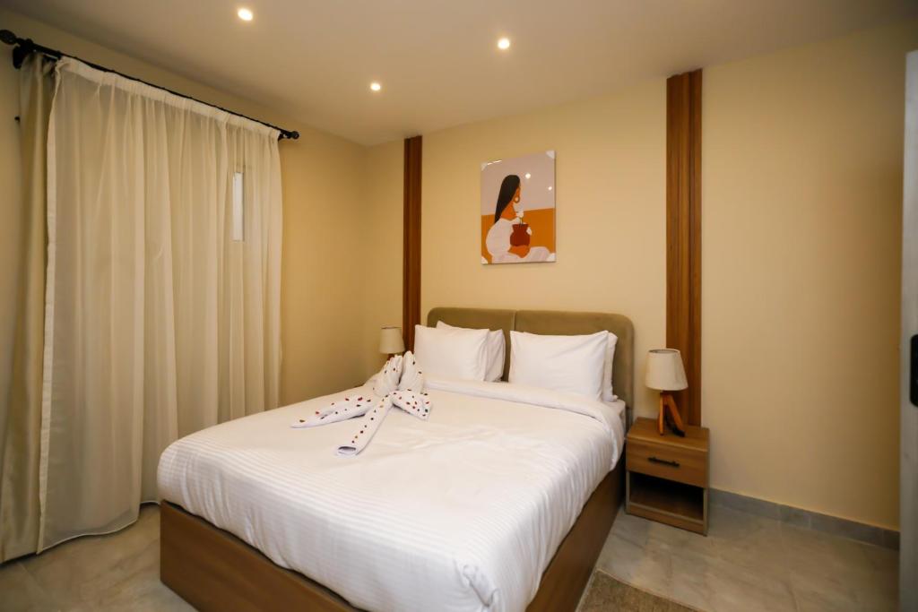 ein Schlafzimmer mit einem großen Bett mit weißer Bettwäsche in der Unterkunft pyramids palace view iNN in Kairo