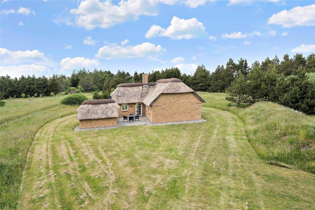 una vecchia casa con un tetto in erba in un campo di 60857-Ulfborg-Illeborgvej-38 a Fjand Gårde