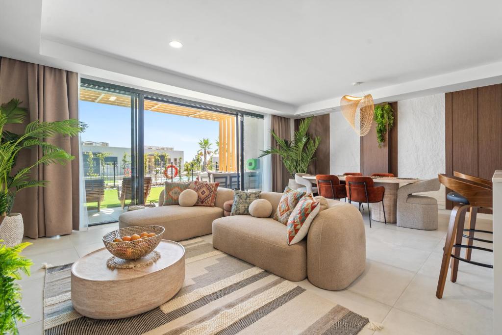 a living room with couches and a table and a kitchen at Evergreen Exclusive in Mijas Costa