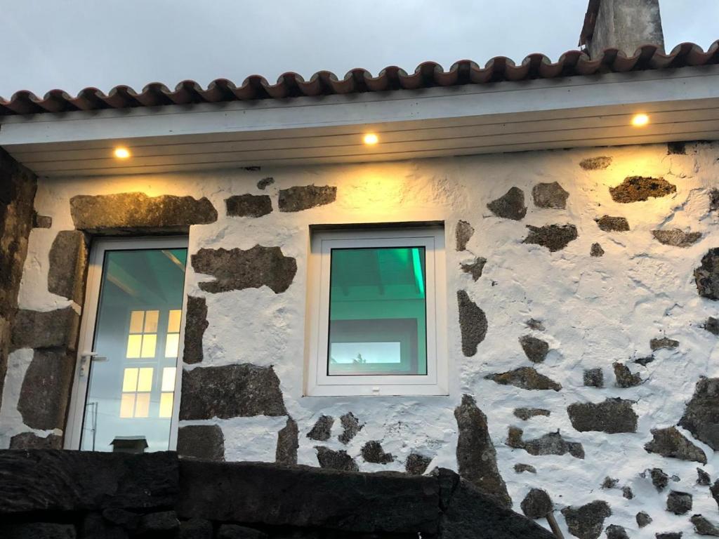 - un bâtiment en pierre avec deux fenêtres dans l'établissement Ferreiro do Cabeço House, à Bandeiras