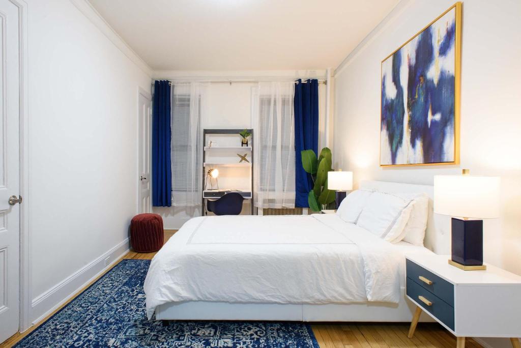 ニューヨークにある1567-1A New 2br PRIME upper East APT W&Dのベッドルーム(白いベッド1台、青いラグ付)