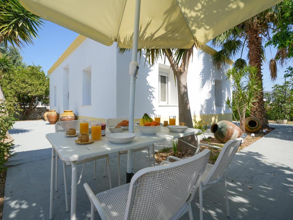 a white table and chairs under an umbrella at Casa Kamara in Kardamaina